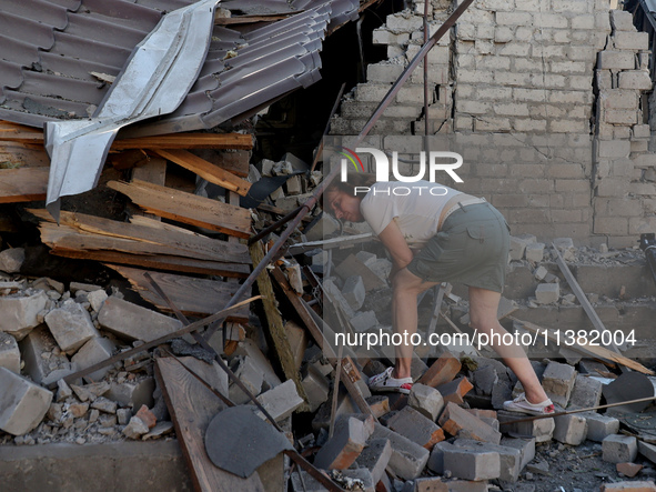 A woman is examining the ruins of a building in a residential area after the Russian glide bomb attack in Kharkiv, Ukraine, on July 3, 2024....