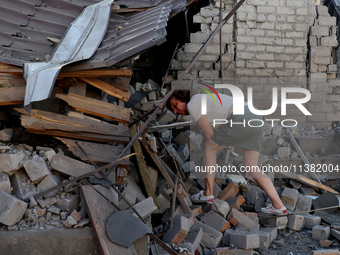 A woman is examining the ruins of a building in a residential area after the Russian glide bomb attack in Kharkiv, Ukraine, on July 3, 2024....