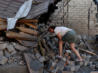 A woman is examining the ruins of a building in a residential area after the Russian glide bomb attack in Kharkiv, Ukraine, on July 3, 2024....