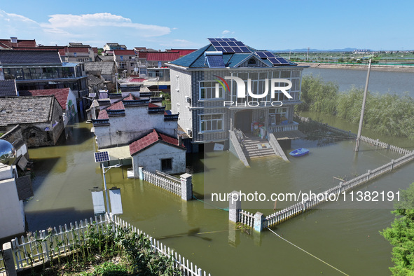 The water level of Shijiu Lake is rising after days of rainstorm, and some surrounding villages are flooding in Nanjing, China, on July 4, 2...