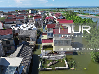 The water level of Shijiu Lake is rising after days of rainstorm, and some surrounding villages are flooding in Nanjing, China, on July 4, 2...