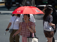 People are walking across the street during the heatwave in Shanghai, China, on July 4, 2024, as the temperature reaches 39 degrees Celsius...