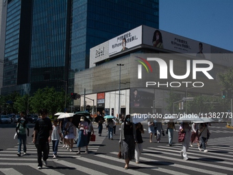 People are walking across the street during the heatwave in Shanghai, China, on July 4, 2024, as the temperature reaches 39 degrees Celsius...