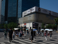 People are walking across the street during the heatwave in Shanghai, China, on July 4, 2024, as the temperature reaches 39 degrees Celsius...