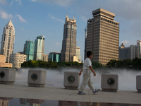 A boy is walking next to the water fountain in the People's Square in Shanghai, China, on July 4, 2024, as the temperature reaches 39 degree...