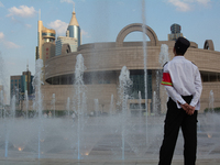 A security worker is standing next to the water fountain in People's Square in Shanghai, China, on July 4, 2024, as the temperature is reach...