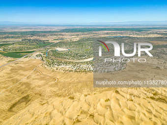 The local forestry department is laying water-saving drip irrigation facilities on the smooth dunes, planting salt-tolerant and drought-tole...