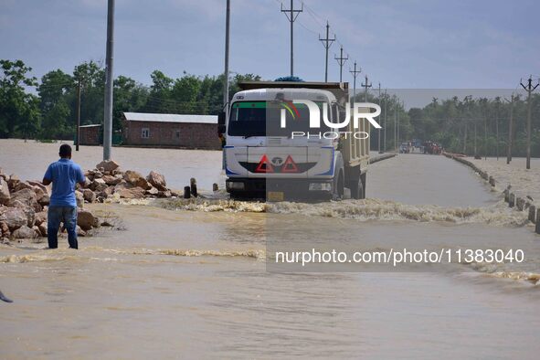 A truck is driving through a flooded road after heavy rainfall in Hojai District of Assam, India, on July 5, 2024. 