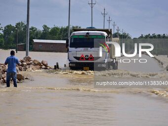 A truck is driving through a flooded road after heavy rainfall in Hojai District of Assam, India, on July 5, 2024. (