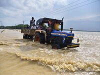 Villagers are crossing a flooded road on a tractor after heavy rainfall in Hojai District of Assam, India, on July 5, 2024. (