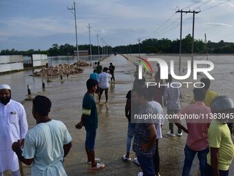 People are looking at a road submerged in flood water after heavy rainfall in Hojai District of Assam, India, on July 5, 2024. (