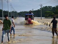 Villagers are crossing a flooded road on a tractor after heavy rainfall in Hojai District of Assam, India, on July 5, 2024. (