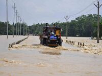 Villagers are crossing a flooded road on a tractor after heavy rainfall in Hojai District of Assam, India, on July 5, 2024. (