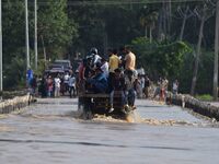 Villagers are crossing a flooded road on a tractor after heavy rainfall in Hojai District of Assam, India, on July 5, 2024. (