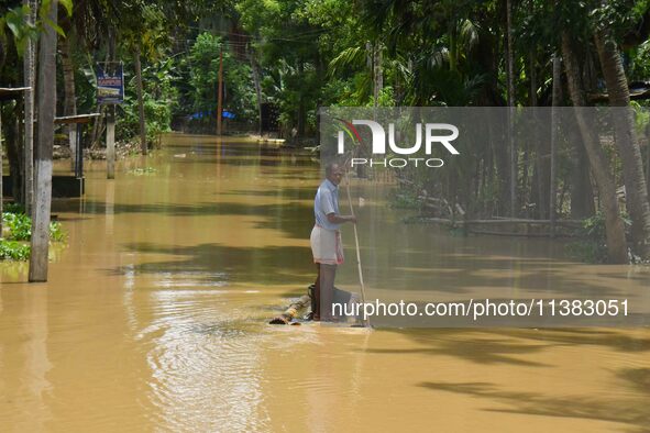 A man is using a banana raft to cross a flooded area after heavy rainfall in Nagaon District of Assam, India, on July 5, 2024. 