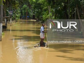 A man is using a banana raft to cross a flooded area after heavy rainfall in Nagaon District of Assam, India, on July 5, 2024. (