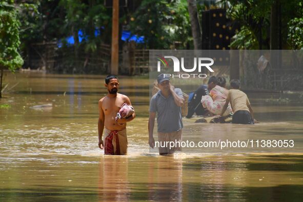 Villagers are walking through a flooded area after heavy rainfall in Nagaon District of Assam, India, on July 5, 2024. 