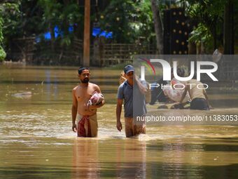 Villagers are walking through a flooded area after heavy rainfall in Nagaon District of Assam, India, on July 5, 2024. (