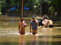 Villagers are walking through a flooded area after heavy rainfall in Nagaon District of Assam, India, on July 5, 2024. (