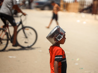 Displaced Palestinians are walking next to a temporary camp in Khan Yunis, south of the Gaza Strip, on July 4, 2024, amid the ongoing confli...