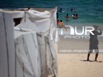 Displaced Palestinians are swimming next to a temporary camp in Khan Yunis, south of the Gaza Strip, on July 4, 2024, amid the ongoing confl...