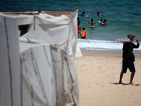 Displaced Palestinians are swimming next to a temporary camp in Khan Yunis, south of the Gaza Strip, on July 4, 2024, amid the ongoing confl...