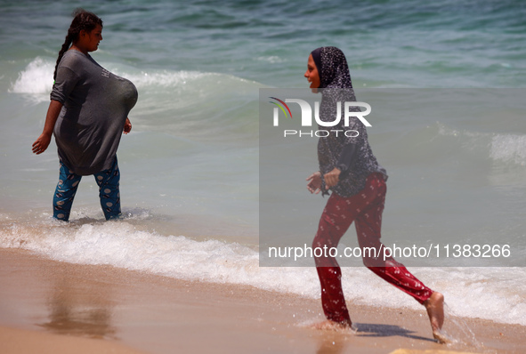 Displaced Palestinians are swimming next to a temporary camp in Khan Yunis, south of the Gaza Strip, on July 4, 2024, amid the ongoing confl...