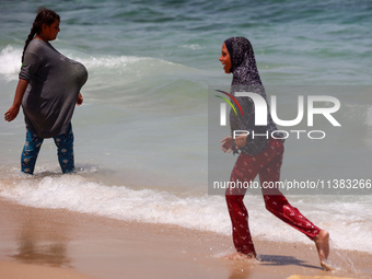 Displaced Palestinians are swimming next to a temporary camp in Khan Yunis, south of the Gaza Strip, on July 4, 2024, amid the ongoing confl...