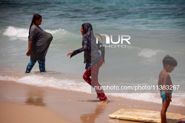 Displaced Palestinians are swimming next to a temporary camp in Khan Yunis, south of the Gaza Strip, on July 4, 2024, amid the ongoing confl...