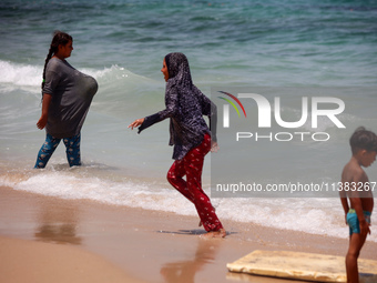 Displaced Palestinians are swimming next to a temporary camp in Khan Yunis, south of the Gaza Strip, on July 4, 2024, amid the ongoing confl...