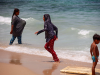 Displaced Palestinians are swimming next to a temporary camp in Khan Yunis, south of the Gaza Strip, on July 4, 2024, amid the ongoing confl...