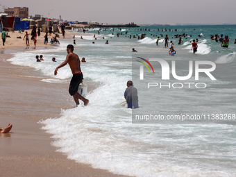 Displaced Palestinians are swimming next to a temporary camp in Khan Yunis, south of the Gaza Strip, on July 4, 2024, amid the ongoing confl...