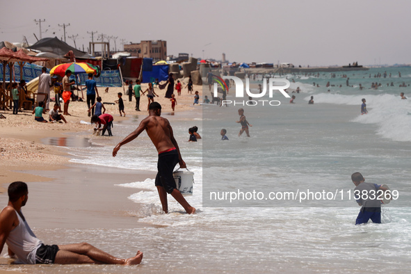 Displaced Palestinians are swimming next to a temporary camp in Khan Yunis, south of the Gaza Strip, on July 4, 2024, amid the ongoing confl...