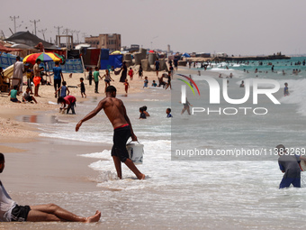 Displaced Palestinians are swimming next to a temporary camp in Khan Yunis, south of the Gaza Strip, on July 4, 2024, amid the ongoing confl...