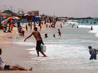 Displaced Palestinians are swimming next to a temporary camp in Khan Yunis, south of the Gaza Strip, on July 4, 2024, amid the ongoing confl...