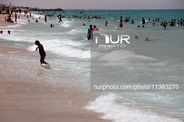 Displaced Palestinians are swimming next to a temporary camp in Khan Yunis, south of the Gaza Strip, on July 4, 2024, amid the ongoing confl...