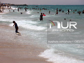 Displaced Palestinians are swimming next to a temporary camp in Khan Yunis, south of the Gaza Strip, on July 4, 2024, amid the ongoing confl...