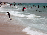 Displaced Palestinians are swimming next to a temporary camp in Khan Yunis, south of the Gaza Strip, on July 4, 2024, amid the ongoing confl...