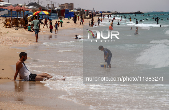 Displaced Palestinians are swimming next to a temporary camp in Khan Yunis, south of the Gaza Strip, on July 4, 2024, amid the ongoing confl...