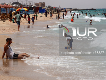 Displaced Palestinians are swimming next to a temporary camp in Khan Yunis, south of the Gaza Strip, on July 4, 2024, amid the ongoing confl...