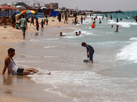 Displaced Palestinians are swimming next to a temporary camp in Khan Yunis, south of the Gaza Strip, on July 4, 2024, amid the ongoing confl...