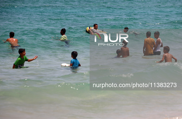 Displaced Palestinians are swimming next to a temporary camp in Khan Yunis, south of the Gaza Strip, on July 4, 2024, amid the ongoing confl...