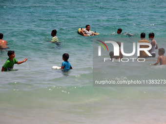 Displaced Palestinians are swimming next to a temporary camp in Khan Yunis, south of the Gaza Strip, on July 4, 2024, amid the ongoing confl...