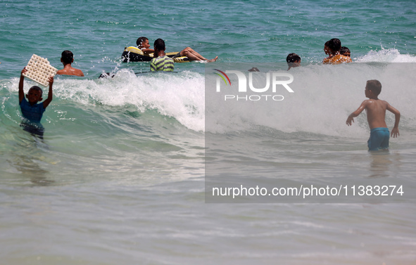 Displaced Palestinians are swimming next to a temporary camp in Khan Yunis, south of the Gaza Strip, on July 4, 2024, amid the ongoing confl...