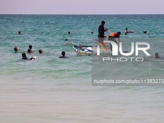 Displaced Palestinians are swimming next to a temporary camp in Khan Yunis, south of the Gaza Strip, on July 4, 2024, amid the ongoing confl...