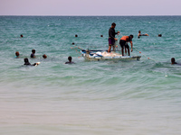 Displaced Palestinians are swimming next to a temporary camp in Khan Yunis, south of the Gaza Strip, on July 4, 2024, amid the ongoing confl...