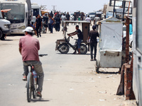 Displaced Palestinians are walking next to a temporary camp in Khan Yunis, south of the Gaza Strip, on July 4, 2024, amid the ongoing confli...