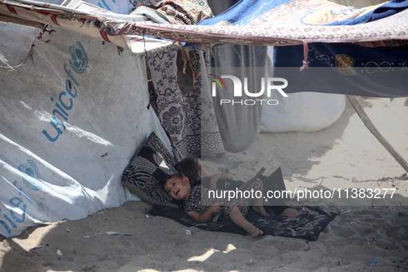 Displaced Palestinians are being seen next to a temporary camp in Khan Yunis, south of the Gaza Strip, on July 4, 2024, amid the ongoing con...