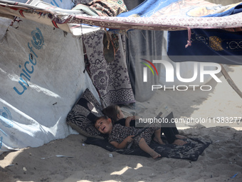 Displaced Palestinians are being seen next to a temporary camp in Khan Yunis, south of the Gaza Strip, on July 4, 2024, amid the ongoing con...