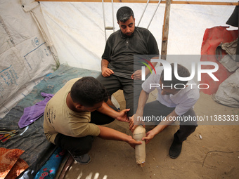 Muattaz Abu Dayeh, a physiotherapist, is applying a medical prosthesis to 32-year-old worker Majd al-Omari, who lost part of his leg during...